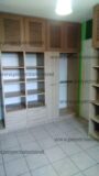 Walk in closet con puertas abatibles con diseño en la parte de arriba, con puerta corrediza en el area del serchero, gavetas utilitarias